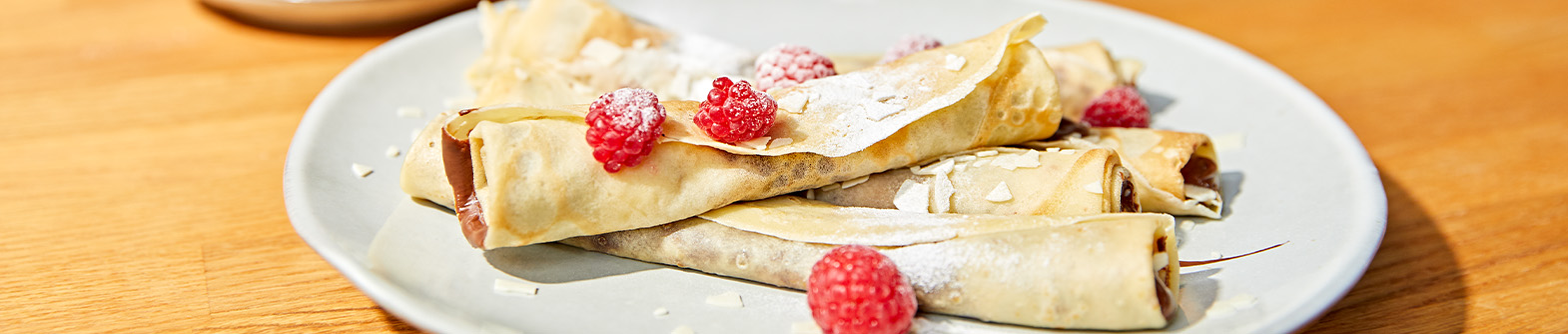 Das Bild zeigt Crêpe mit Himbeeren und Schokoladencreme.