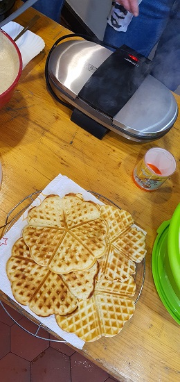 Ein Waffeleisen und mehrere gebackene Waffeln