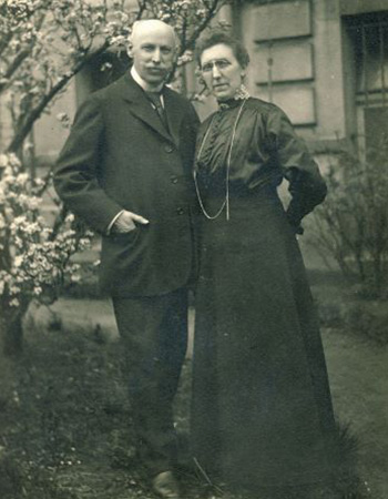 Das ist ein schwarz-weiß Foto von Caspar und Dina Cloer, die in ihrem Garten stehen. 