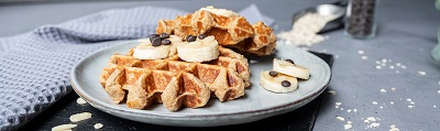 Das Bild zeigt zwei belgische Waffeln dekoriert mit Bananenscheiben. 